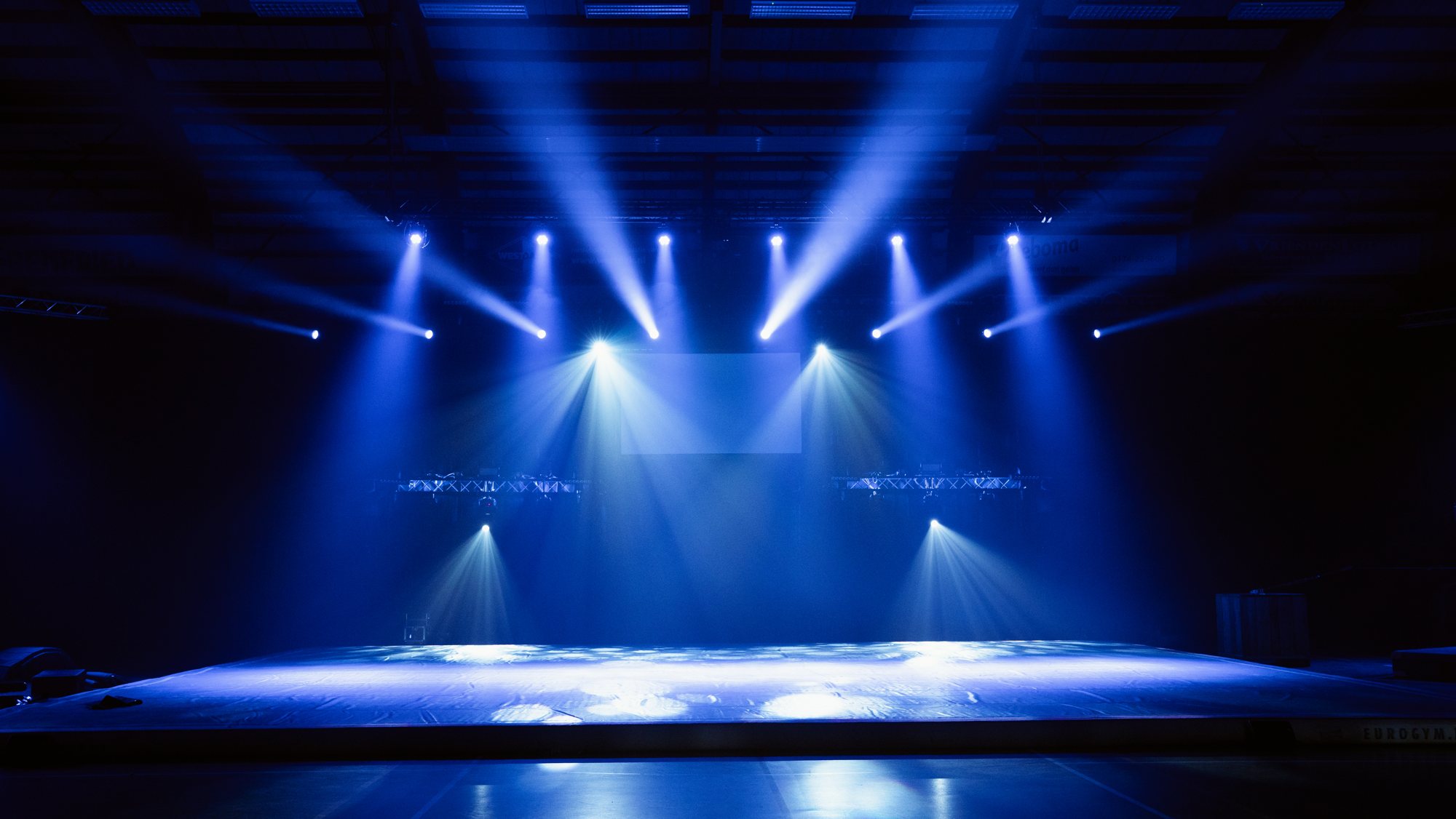 Podium in blauw licht, opstelling van FW Sound & Light